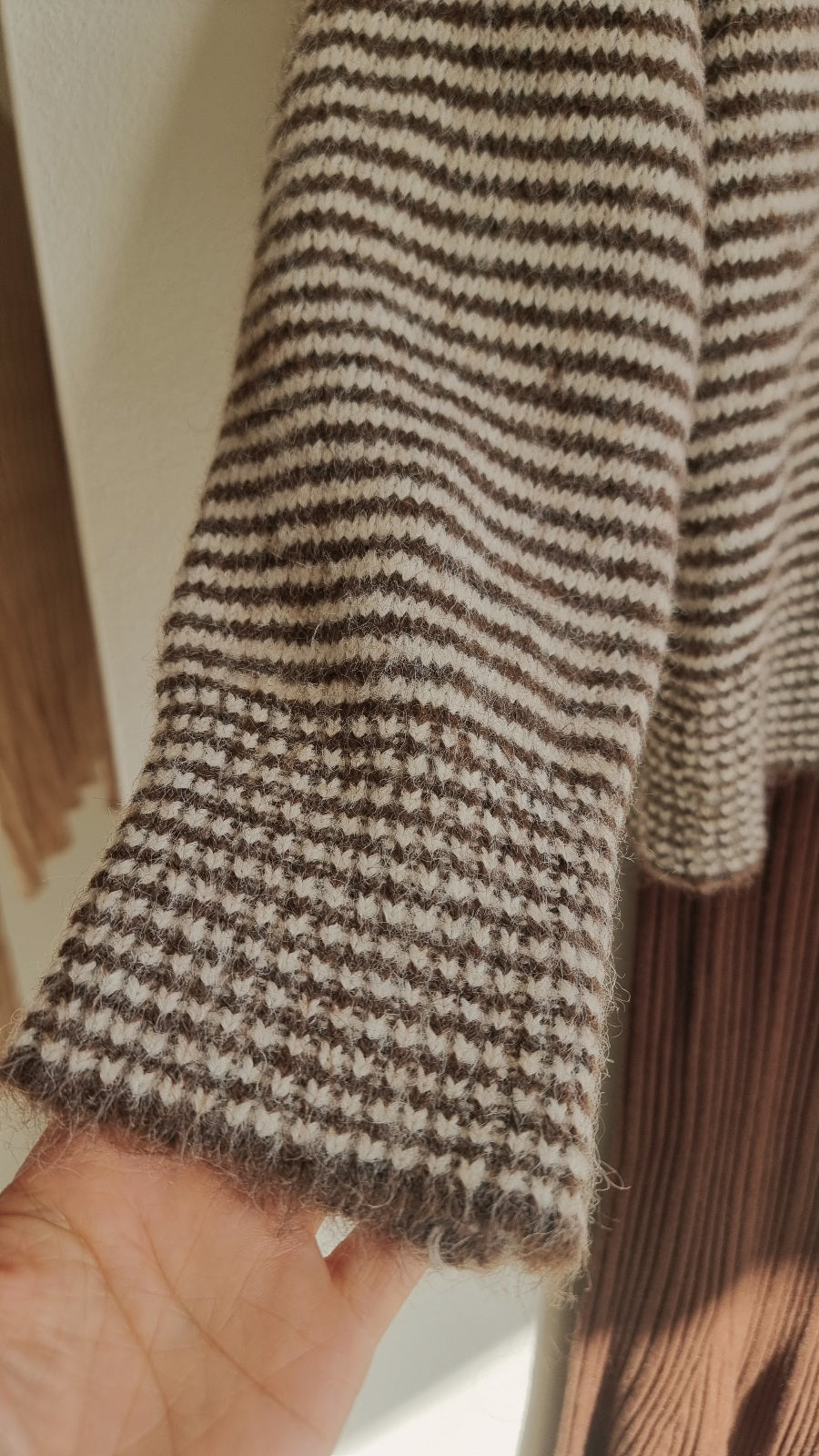 Close-up sleeve detail of brown wool stripe cardigan