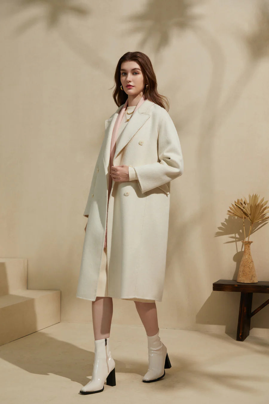 Full-length view of woman wearing cream merino wool coat styled with a minimal outfit