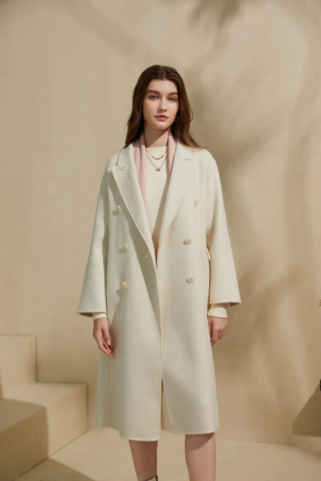Side angle view of cream merino wool coat showing length and structure