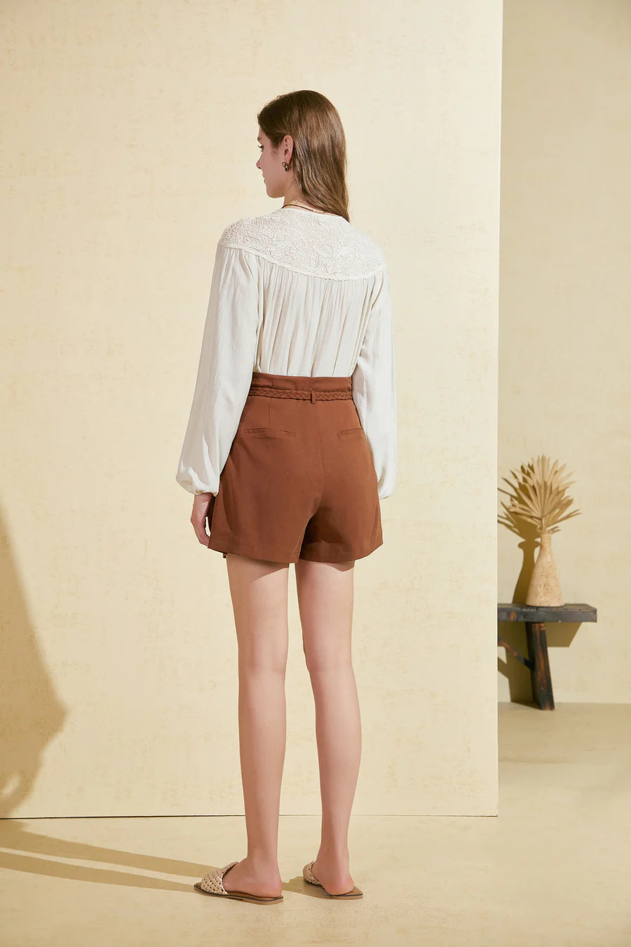 Back-angle close-up of waistband and pleat construction