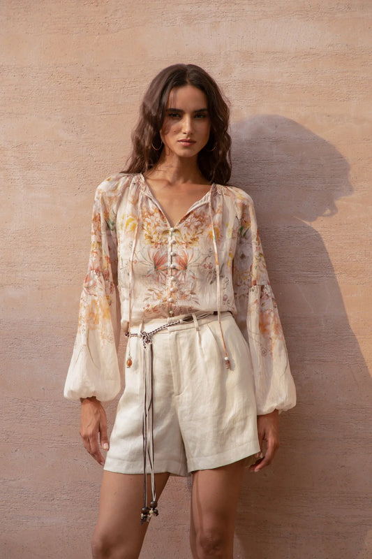 “Model wearing the Atticus printed blouse in soft watercolor floral, front view.”