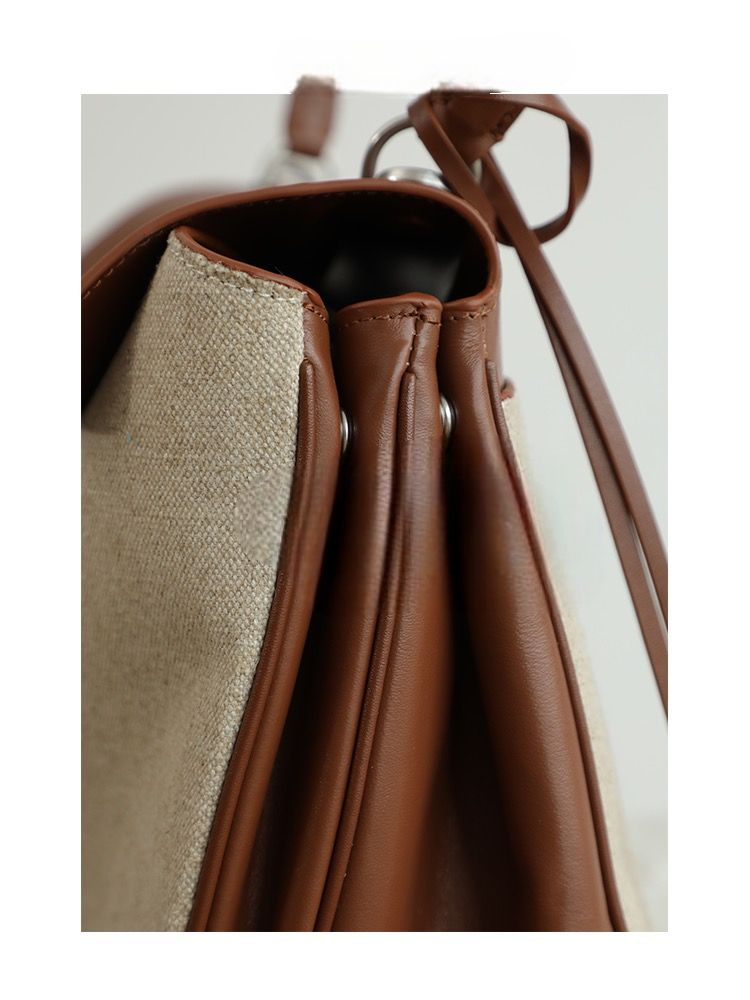 Close-up side view of canvas and brown leather bag with structured panels