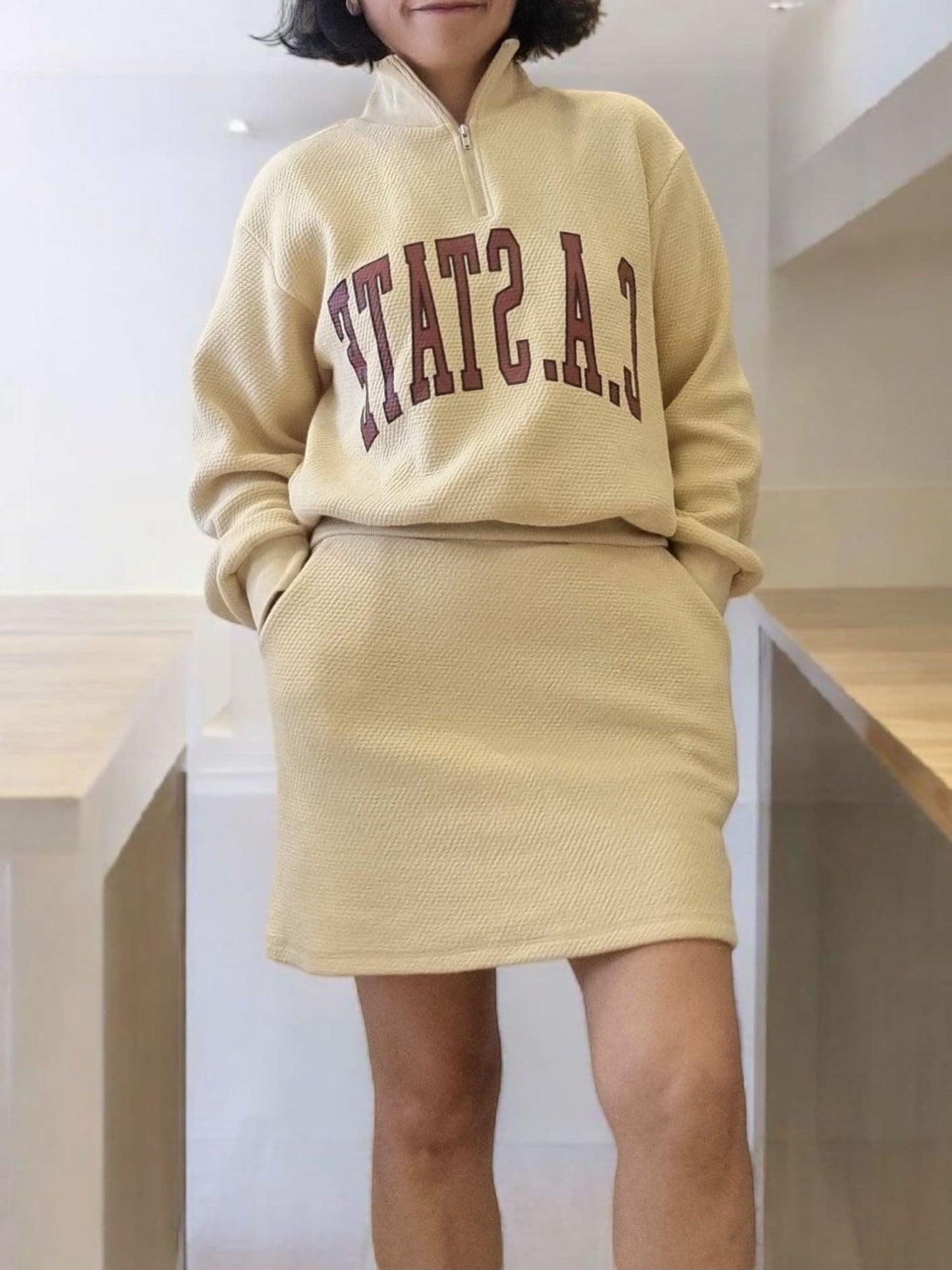Model wearing beige zip-up sweatshirt – cropped front view