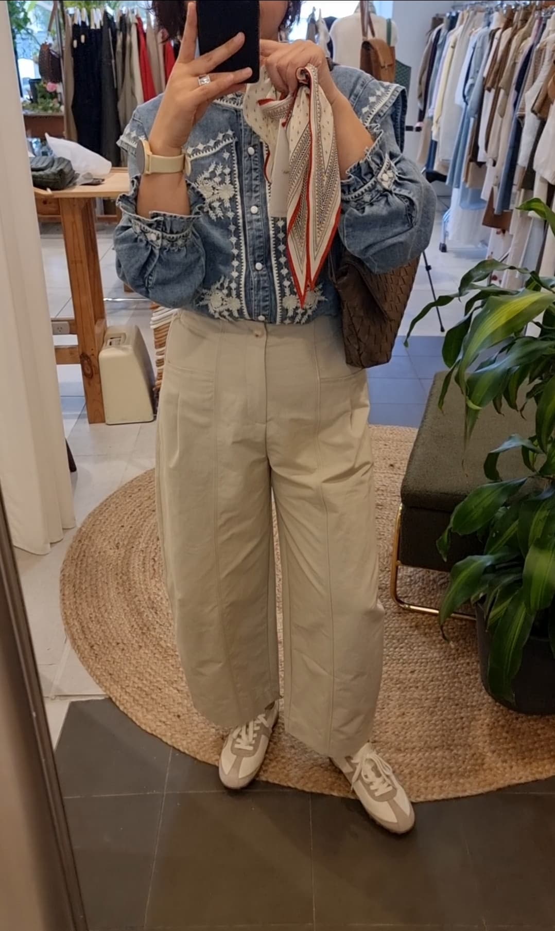 Model standing wearing white and grey leather fabric sneakers