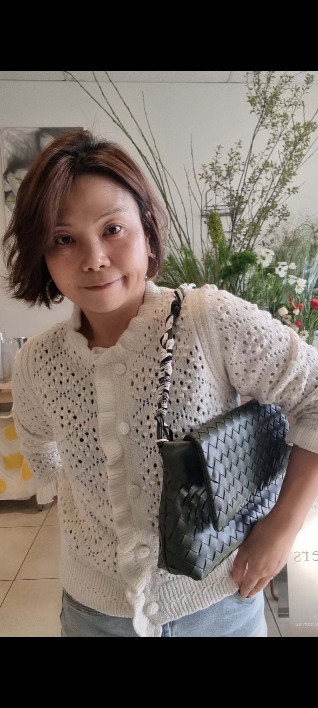 Woman holding bag wearing cream alpaca cardigan casual chic look