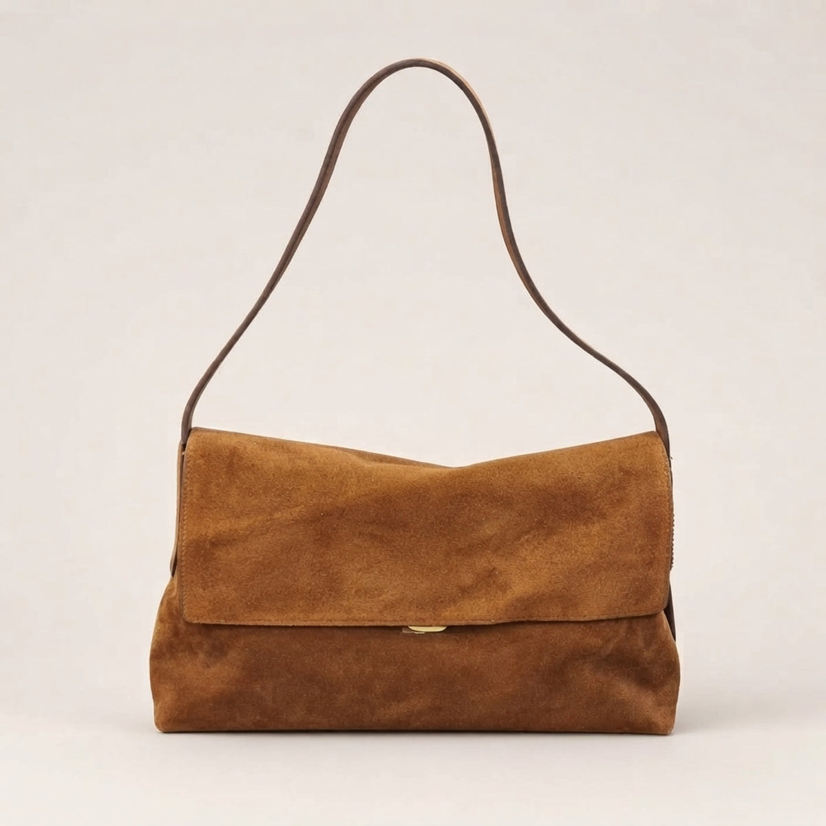 A medium brown suede shoulder bag with a flap closure and a thin matching brown strap, photographed against a neutral light beige background.