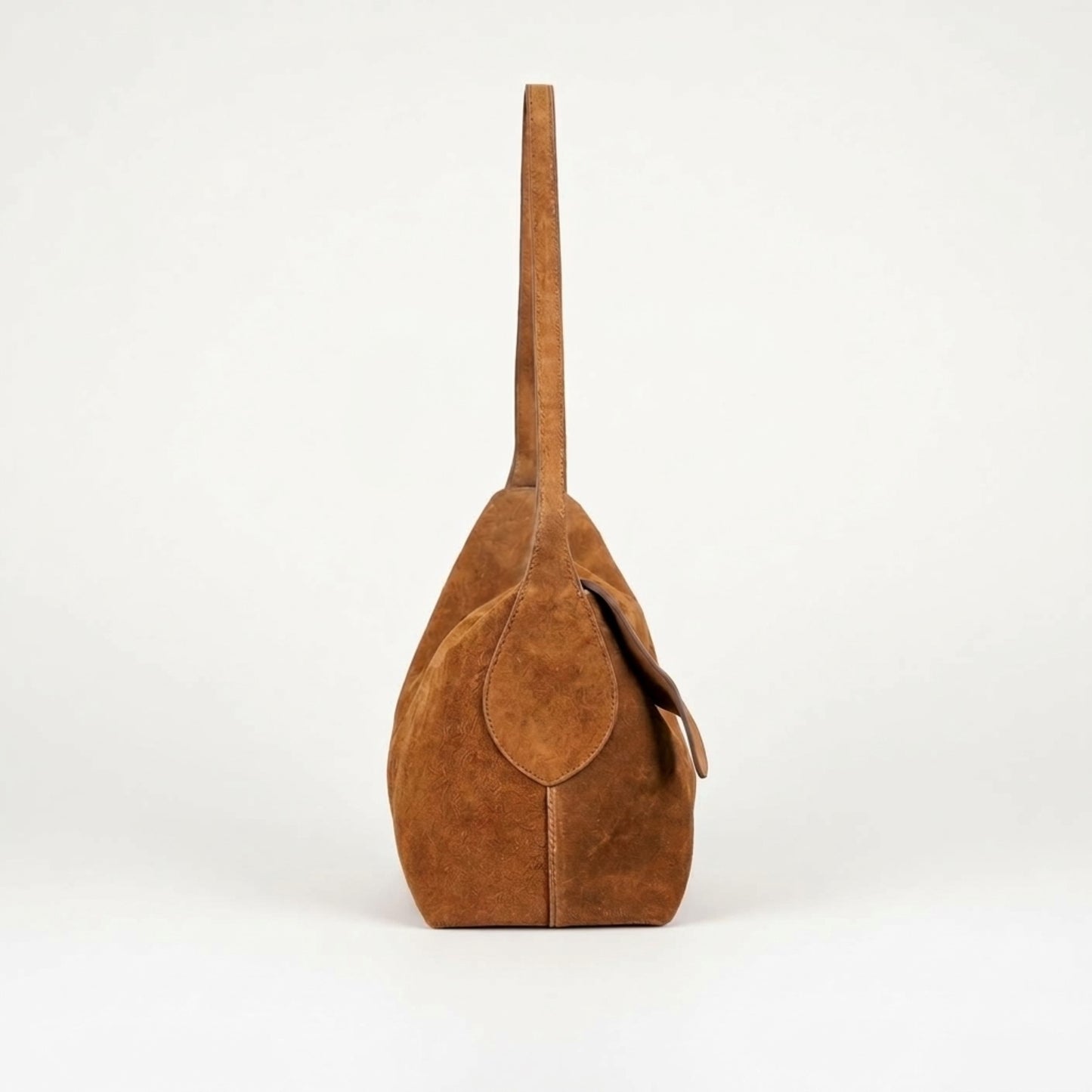 A brown suede shoulder bag with a single strap, shown from the side against a plain white background.