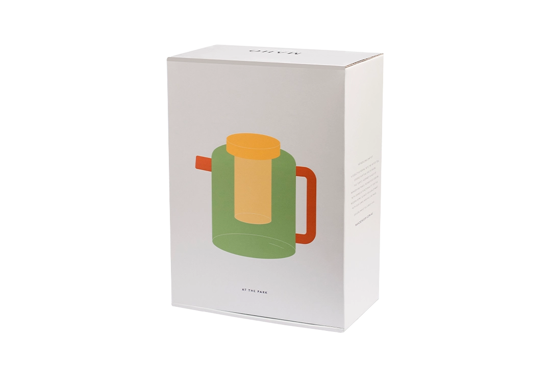 White product box featuring an illustration of the green Cha Pot with a yellow lid and orange handle on a transparent background