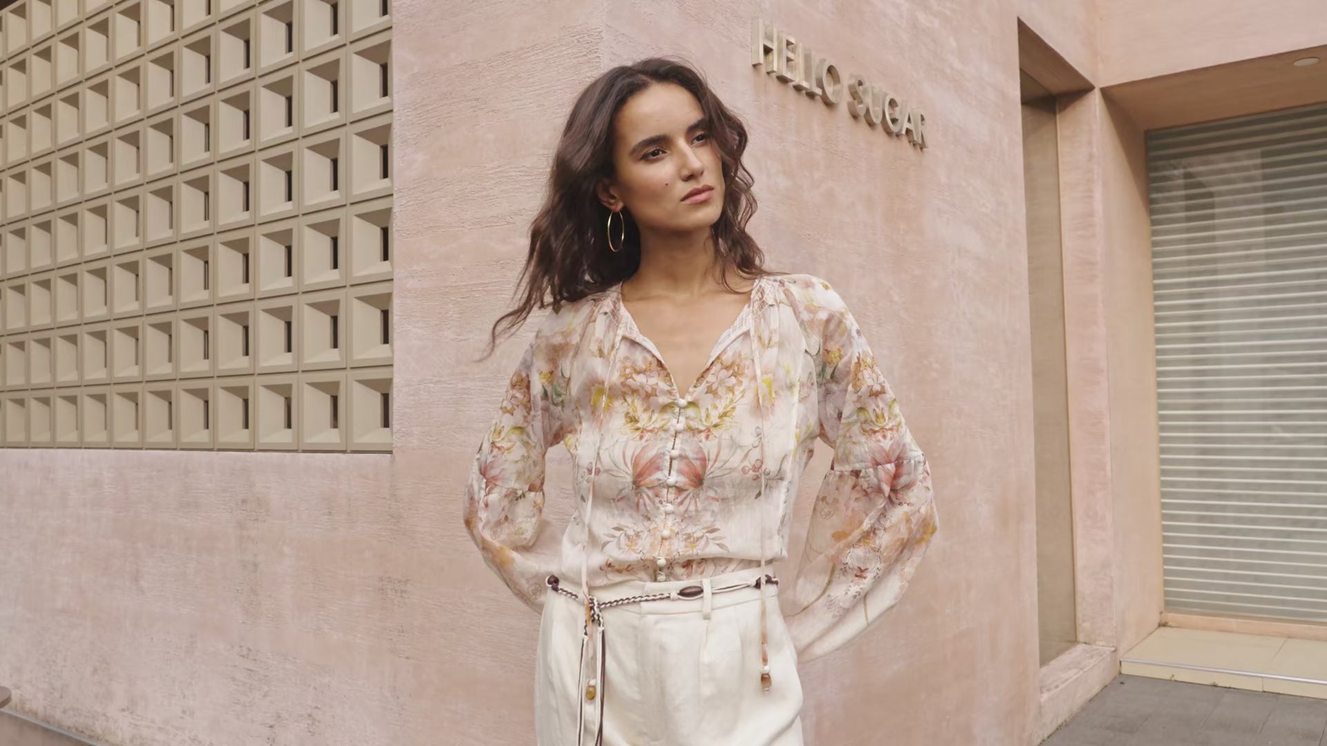“Model wearing a floral blouse in soft neutral tones — showcasing the romantic print, lightweight fabric movement, and relaxed feminine silhouette. Flowy floral top styling, elegant everyday wear, Korean fashion inspired blouse.”