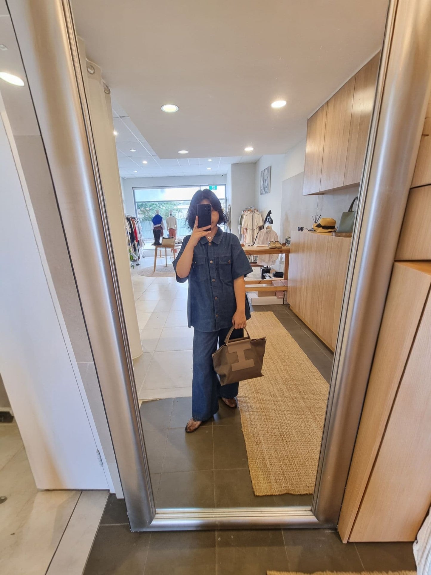 Brown EB bag placed on the floor showing strap and side profile.