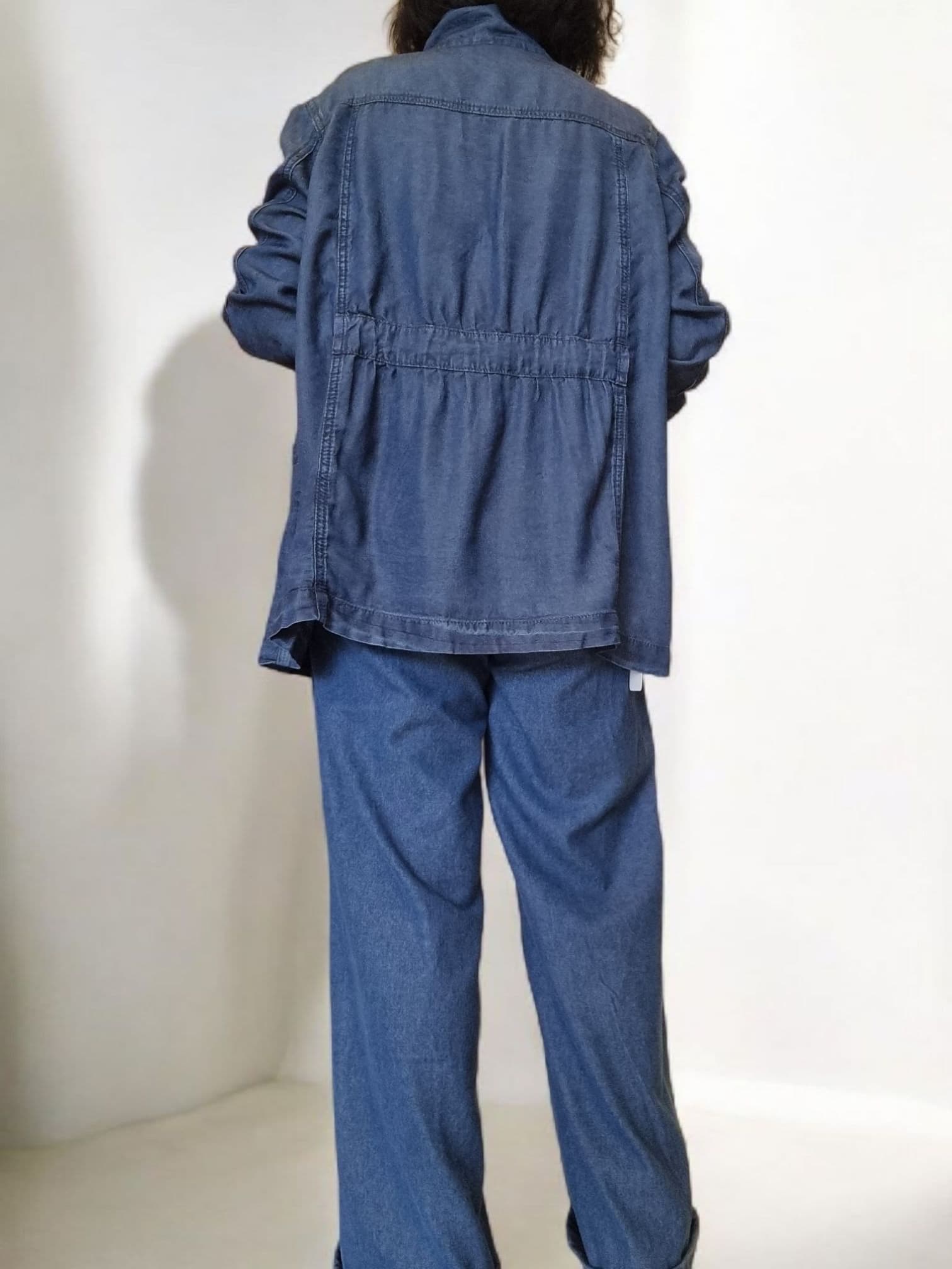 “Blue cotton jacket hanging on a hanger showing double-button design.”