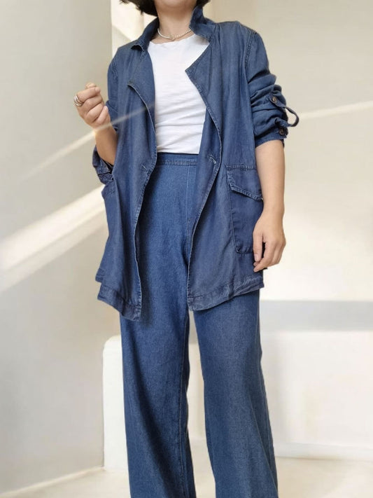 “Front pose of blue cotton jacket styled casually with white top and blue pants.”