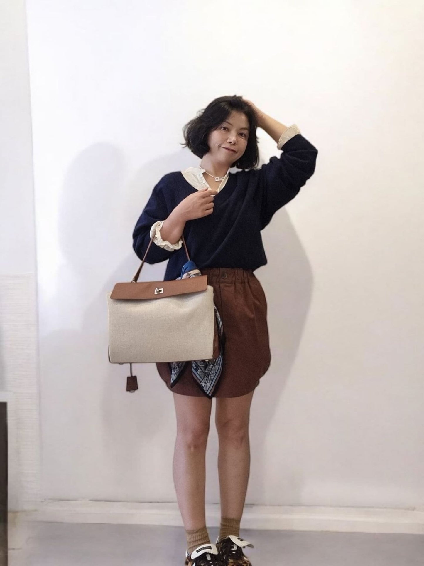 Model posing with brown pumpkin skirt, full outfit view.