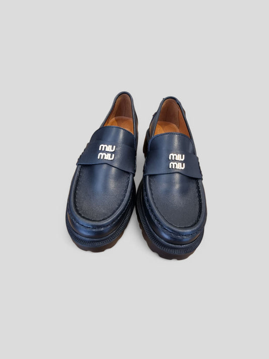 “Pair of black genuine leather loafers displayed on a light backdrop.”