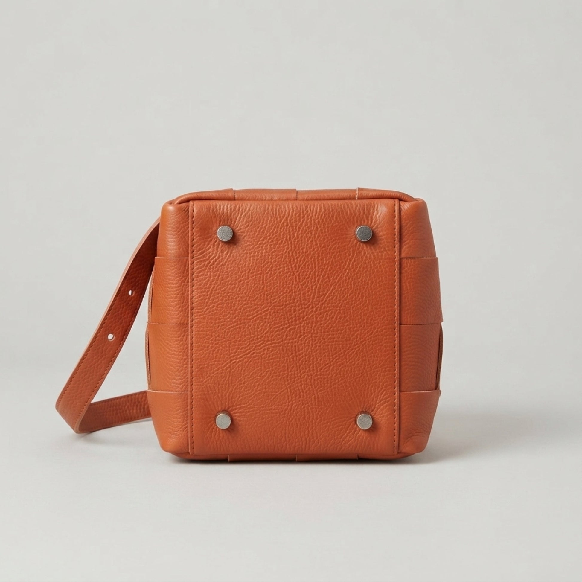 Bottom view of brown woven genuine leather bag with protective feet