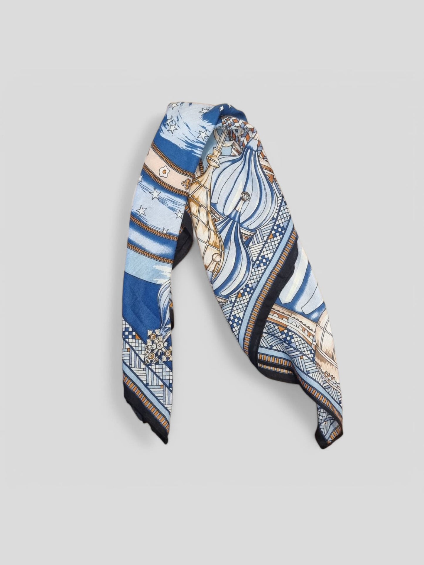 “Folded blue patterned scarf showing detailed print design.”