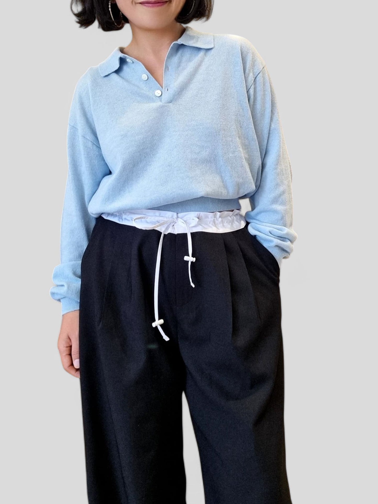 “Blue cotton top styled with navy pants in a minimal setting”