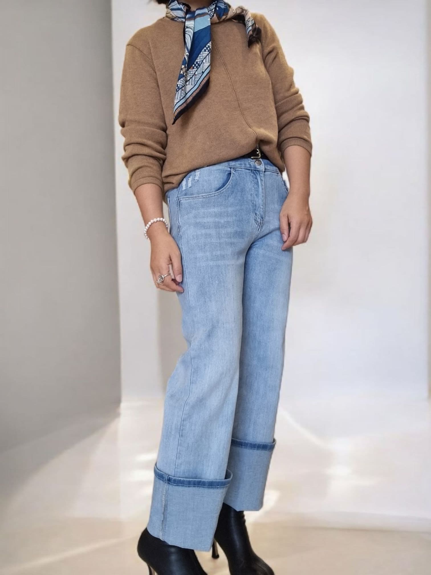 “Side view of blue patterned scarf paired with neutral-toned outfit.”