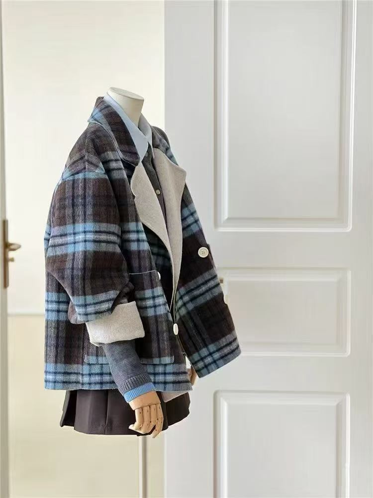 Blue check wool jacket crafted from 100% wool, featuring a relaxed oversized fit, soft structure, rolled contrast cuffs, and a classic double-breasted design for effortless winter layering.