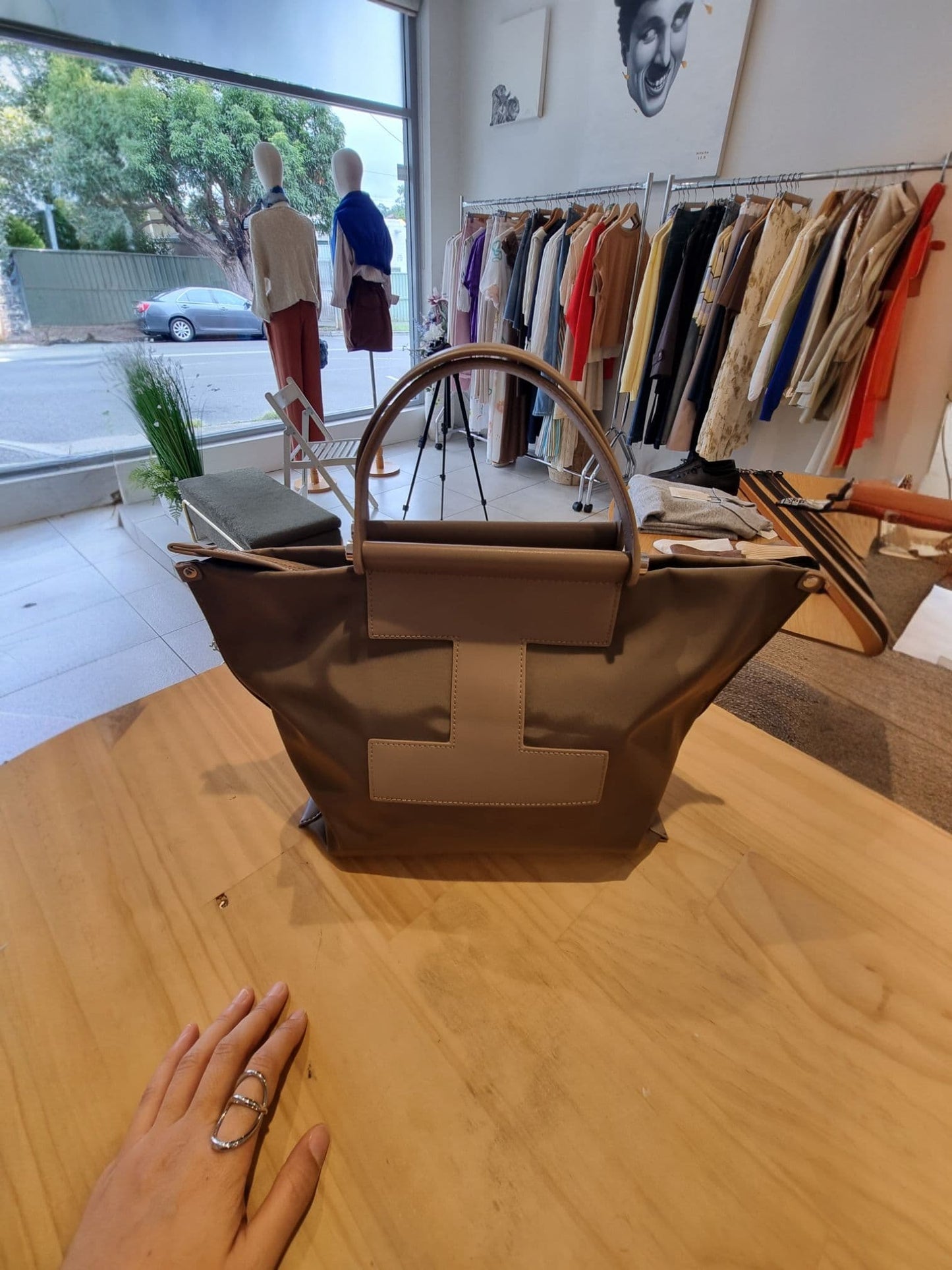 Brown EB bag displayed on a chair in a boutique setting.